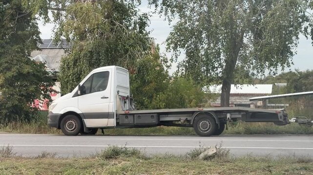 Cars passing a parked white flatbed truck