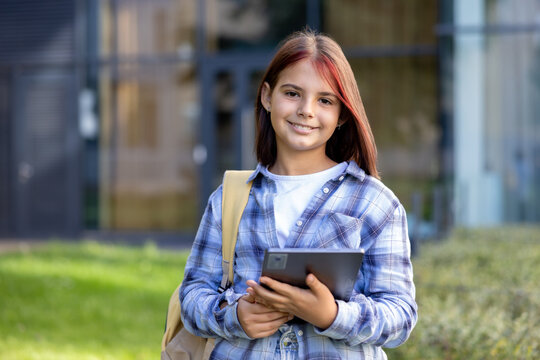 Young student girl smiling holding digital tablet