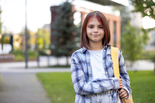Confident student girl walking to school outdoors