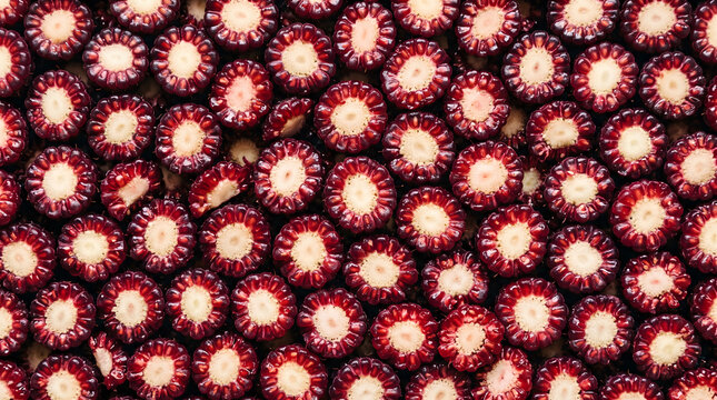 Seamless pattern of sliced dark red loganberry fruit macro close up flat lay top view texture background