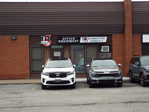 Gloucester, Ontario, Canada &ndash; July 19, 2026: The "M5 Digital office equipment" storefront features business signs and parked cars in front of the commercial brick building  at 5350 Canotek Road.