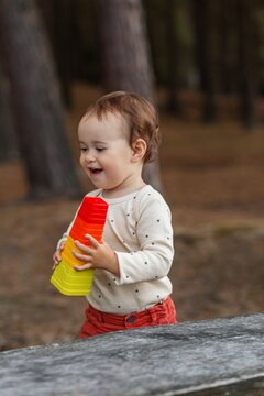 Toddler laughing joyfully while holding stacking pyramid toy