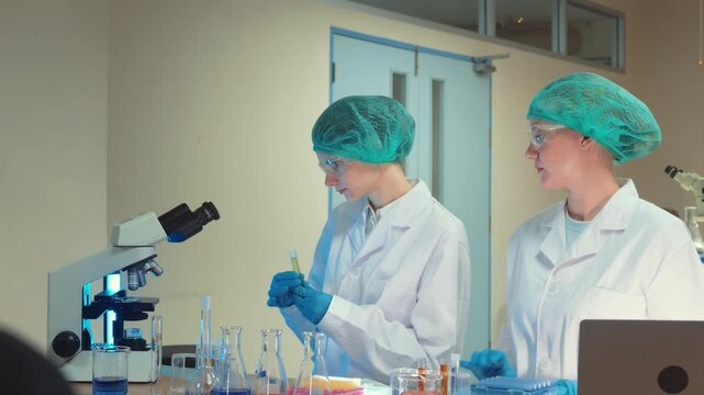 Scientist in a laboratory using a microscope and pipette for precise chemical sample analysis