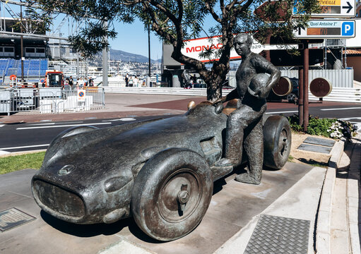 Monaco, Monaco - April 04, 2026: Bronze monument to Juan Manuel Fangio beside a Mercedes-Benz W196 race car near Port Hercule in La Condamine.