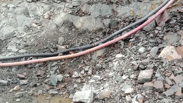 Industrial Water Drainage Pipes Laid On Rocky Ground In Quarry Mine