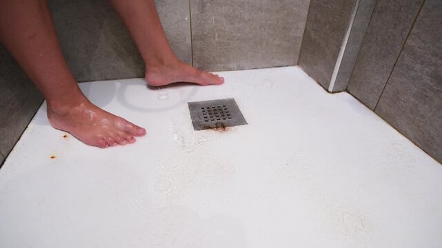 Wet shower floor with a clump of fallen hair near the drain, illustrating hair loss, excessive shedding, bathroom hygiene and concerns about hair and scalp health