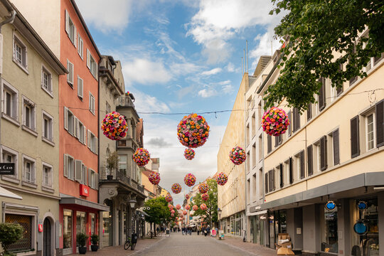 Konstanz, Germany- May 28, 2025: Konstanz old town (altstadt) flower balls colorful decorations hanging above street alley