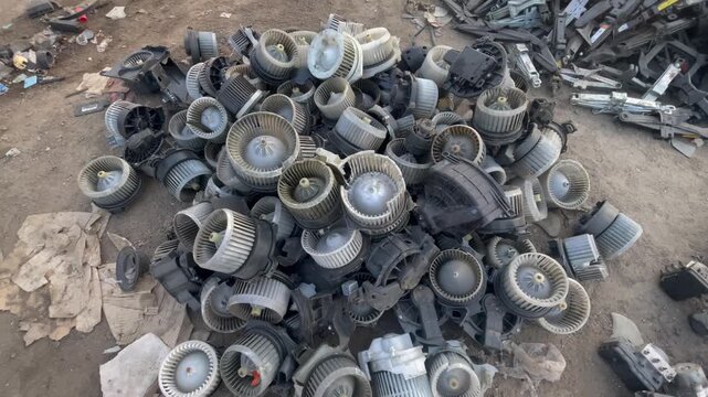 Used Automotive HVAC Blower Motors and Plastic Fan Assemblies in Salvage Yard,  Suitable for automotive maintenance, vehicle ventilation, spare parts, and automobile recycling concepts.
