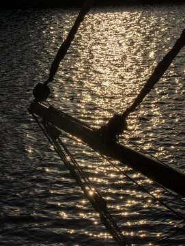 Sailboat Bowsprit Silhouette Against Golden Glittering Sea at Sunset &mdash; Nautical Adventure and Freedom