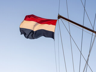 Dutch Flag Flying from Tall Ship Mast Against Clear Blue Sky © Bjorn B
