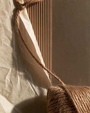Kraft paper and crumpled parchment with jute twine, showing ribbed and fibrous textures in hard raking light for packaging and craft backgrounds
