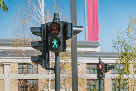 Pedestrian crossing signal illuminating a green walking figure, indicating safety and permission to cross in an urban environment