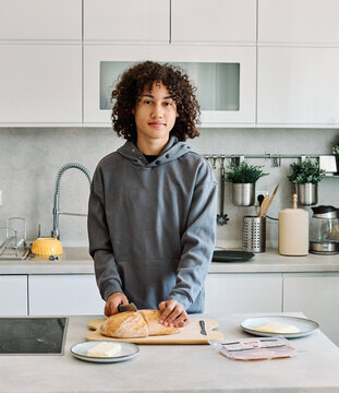 Portrait of a teen boy eating a sandwich in the kitchen
