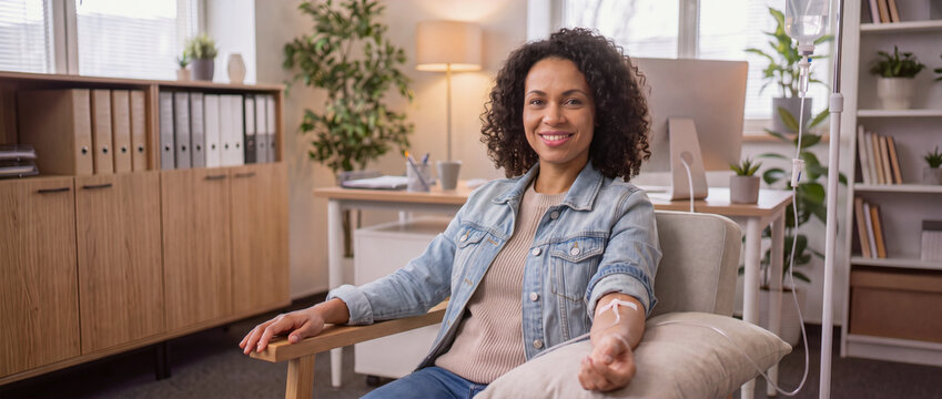 IV drip, smiling business woman in office workplace receiving wellness treatment, hydration, minerals vitamins infusion medical