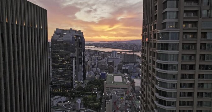 Osaka Japan Aerial v85 lowering flyover between high rise buildings in Ofukacho capturing downtown cityscape of Kita ward and Yodo river at sunset - Shot with 5k Camera - Oct 9th 2023