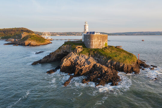 Mumbles lighthouse on rocky coastal island at Sunrise in swansea