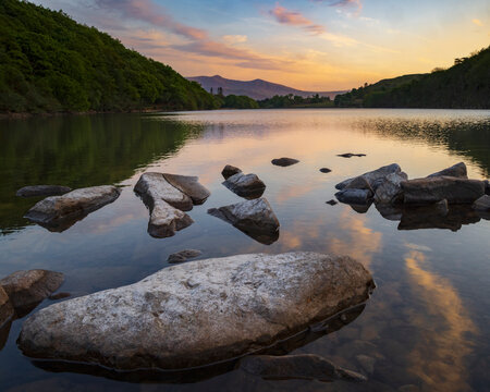 Lake llyn cuinwch at Sunset with calm water and rocks in dolgellau
