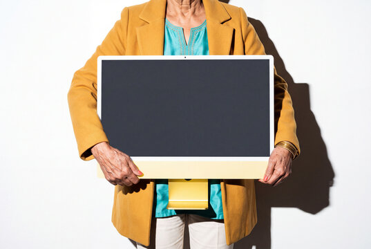 Senior Woman Presenting Yellow Computer