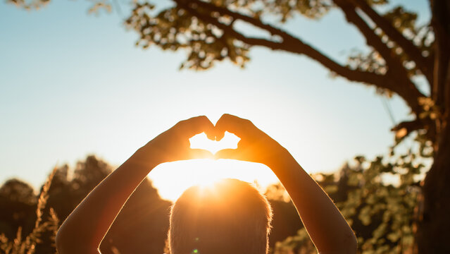 Heart Shape Made With Hands Around Sun at Sunset, Love, Hope, Gratitude, Happiness, Positivity and Spiritual Inspiration Concept

