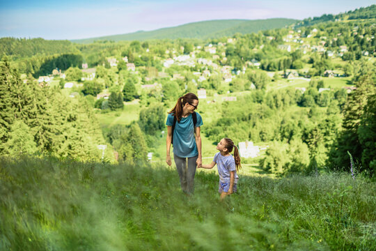 Mother and daughter hiking together in nature, family bonding, motherhood, adventure, healthy lifestyle and outdoor travel concept
