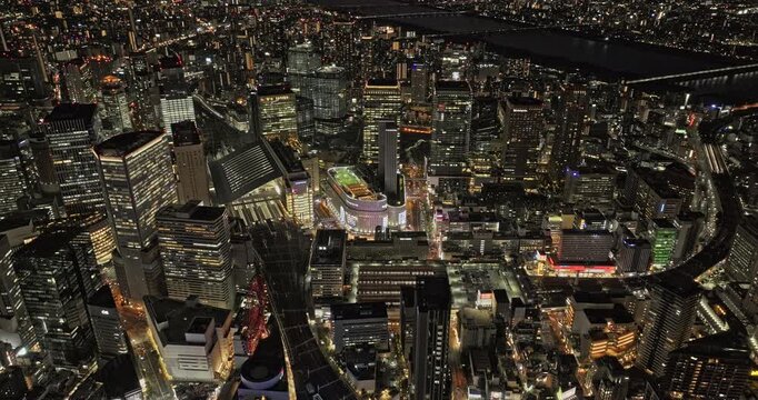 Osaka Japan Aerial v90 birds eye view flyover around the city center showcases vibrant, dense urban sprawl and illuminated downtown cityscape at dusk night - Shot with 5k Camera - Oct 9th 2023