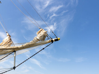 Bowsprit and rigging of a classic tall ship against a bright blue sky with wispy cirrus clouds © Bjorn B
