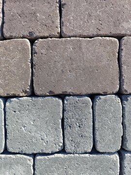 Close up texture of gray and brown interlocking concrete pavement blocks
