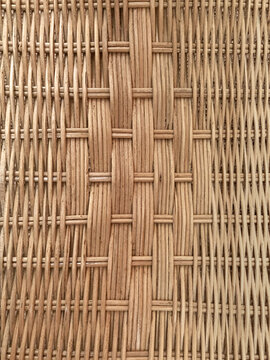 Close-up natural woven reed texture with intricate vertical and horizontal fibers in warm earthy brown tones.