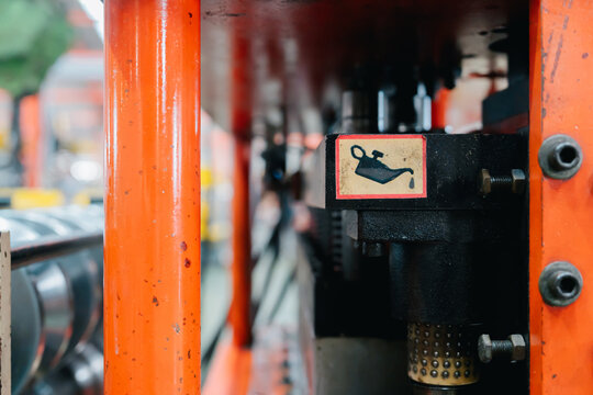 Industry metal sheet factory engineer oil maintenance equipment label on busy manufacturing floor showing focused and prepared mood
