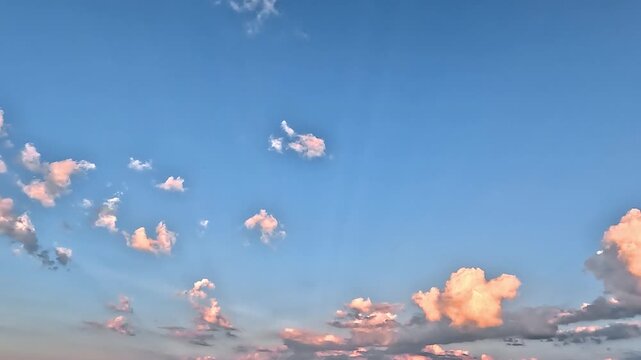 Flowing colorful clouds in the blue skies. 4K video (Ultra High Definition) of cloudscape. Sky and clouds Timelapse. Picturesque summer sunset.