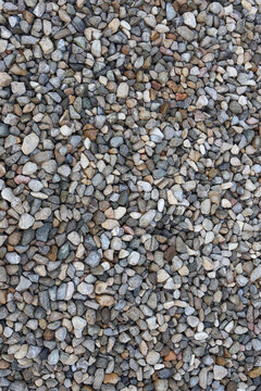 Natural gravel texture with multicolored small stones, rough surfaces, and dense coverage, ideal for landscaping backgrounds.