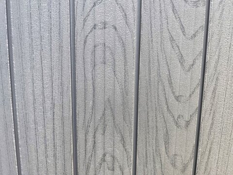 Gray composite wood siding texture with vertical grain pattern
