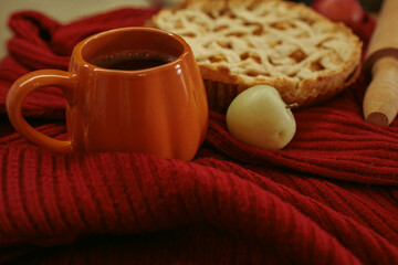 Obraz premium Homemade apple pie with a lattice top next to a cup of hot coffee and an open book, autumn leaf decor, cozy autumn reading setting, film grain effect, high-quality photo