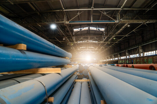 Finished ductile iron pipes stored inside factory, coated pipeline inventory prepared for waterworks, municipal infrastructure and utility construction.