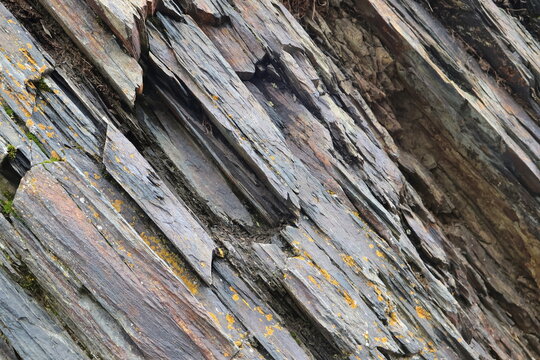 Natural stone background featuring rugged metamorphic rock layers in the mountains