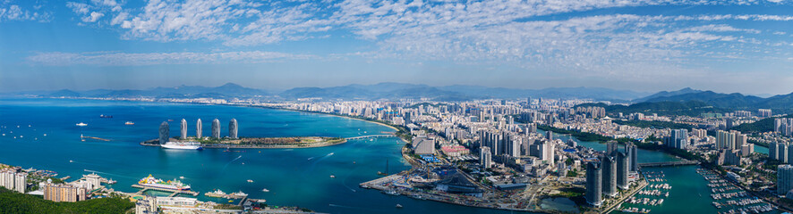 Fototapeta premium Coastal city skyline spanning curved bay aerial panorama