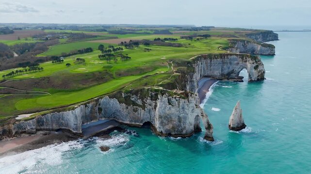 Etretat white cliffs and rock arches along Normandy coast, France. Aerial footage of Aiguille d Etretat coastal formations