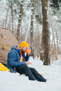 Hiker enjoying hot meal during winter solo camping trip