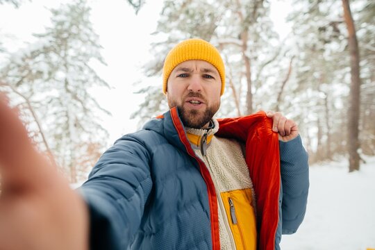 Man filming winter jacket review in snowy forest