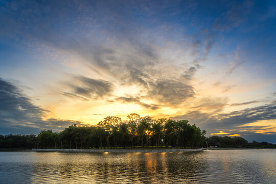 landscape lake views and the reservoir the forest summer water reflection with Twilight blue bright and orange yellow dramatic sunset sky in beach colorful nature background.