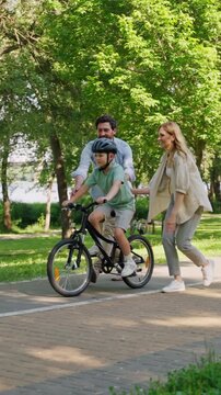 Parents release boy on bicycle and celebrate park lesson success