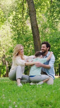 Loving mother and father warmly hug cheerful and energetic son