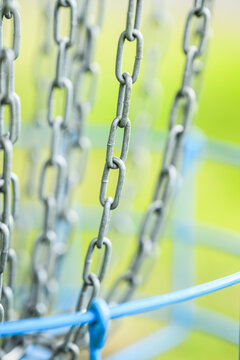 Close up metal chains hanging at outdoor playground.