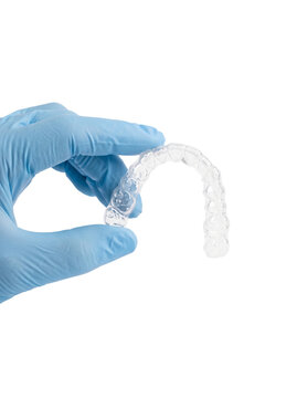 Dentist holding a transparent plastic dental aligner for teeth straightening isolated on transparent background