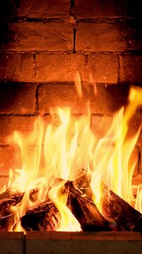 The fire is burning in the fireplace. Slow motion. Vertical video