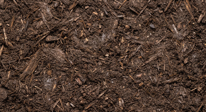 Fermented spent mushroom substrate residue shown as a full-frame field of softened interwoven fibers, decomposed matter, compacted fragments, and moist organic texture