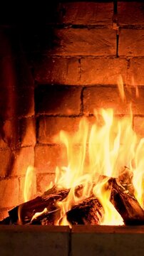 The fire is burning in the fireplace. Slow motion. Vertical video