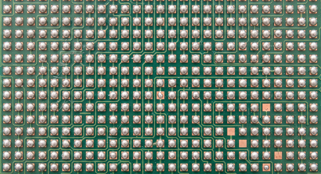 Macro view of a green printed circuit board with ball grid array solder balls