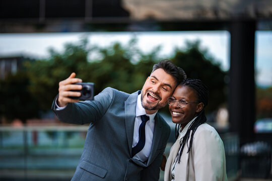 Diverse business professionals taking a happy selfie outdoors