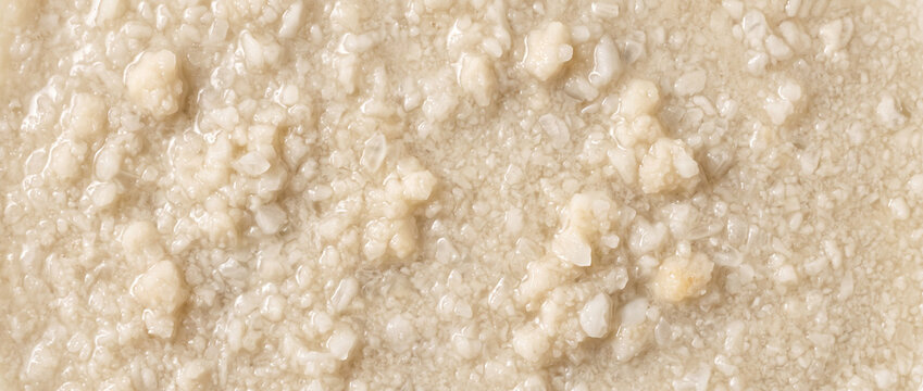 Wet struvite precipitate appearing as pale moist agglomerates with soft mineral clusters and uneven slurry-like texture